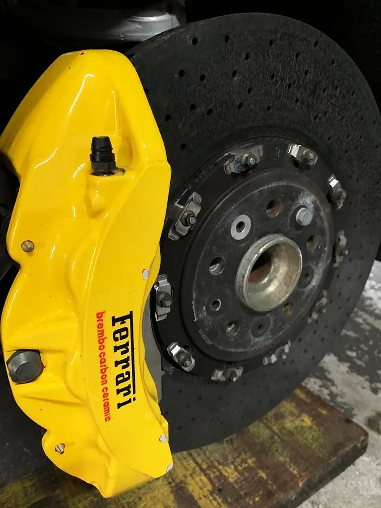 Pinça Ferrari pintada de amarelo sobre disco de freio